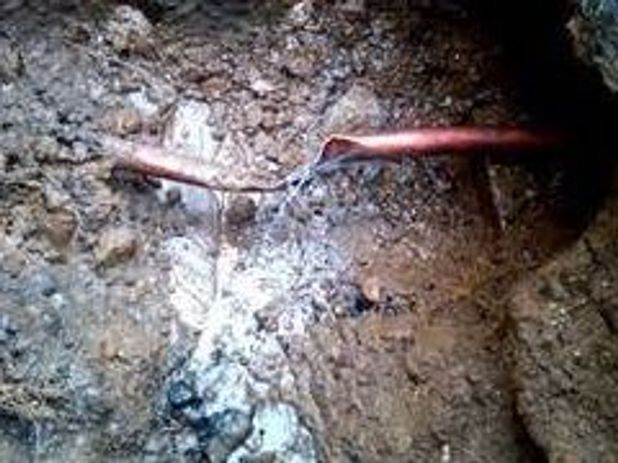 Broken residential water service line exposed during a repair